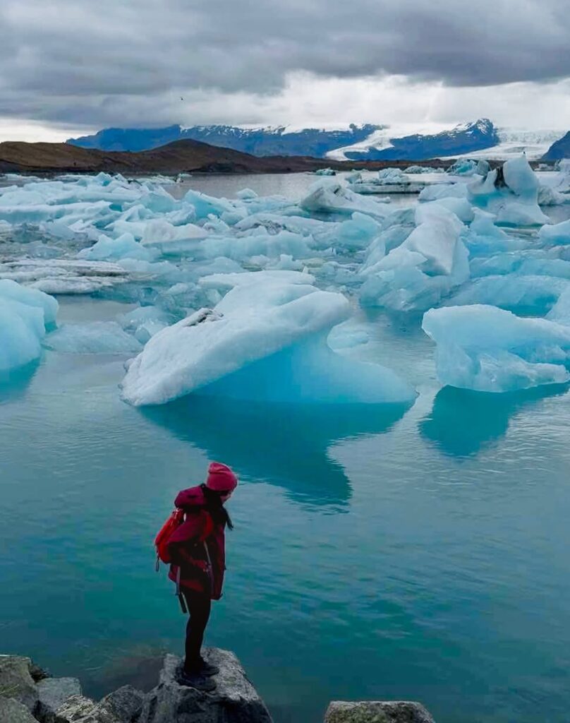 Image of a woman near the edge of a glacier lagoon