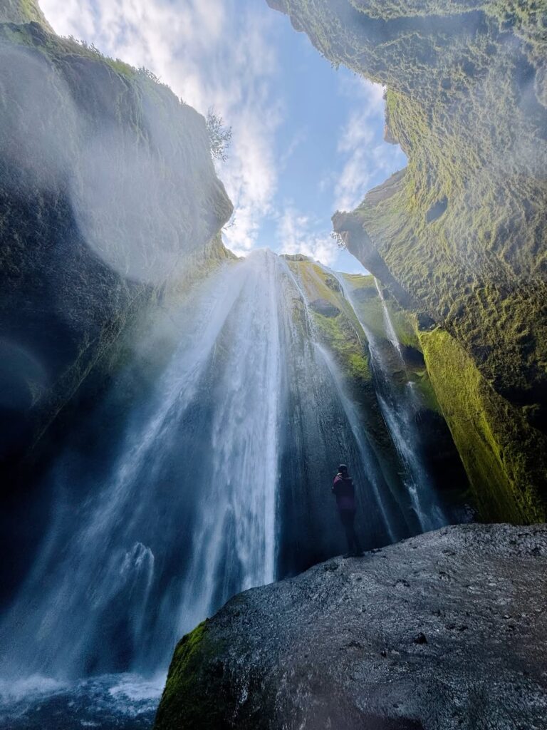 Image of a person looking up from the bottom of a waterfall