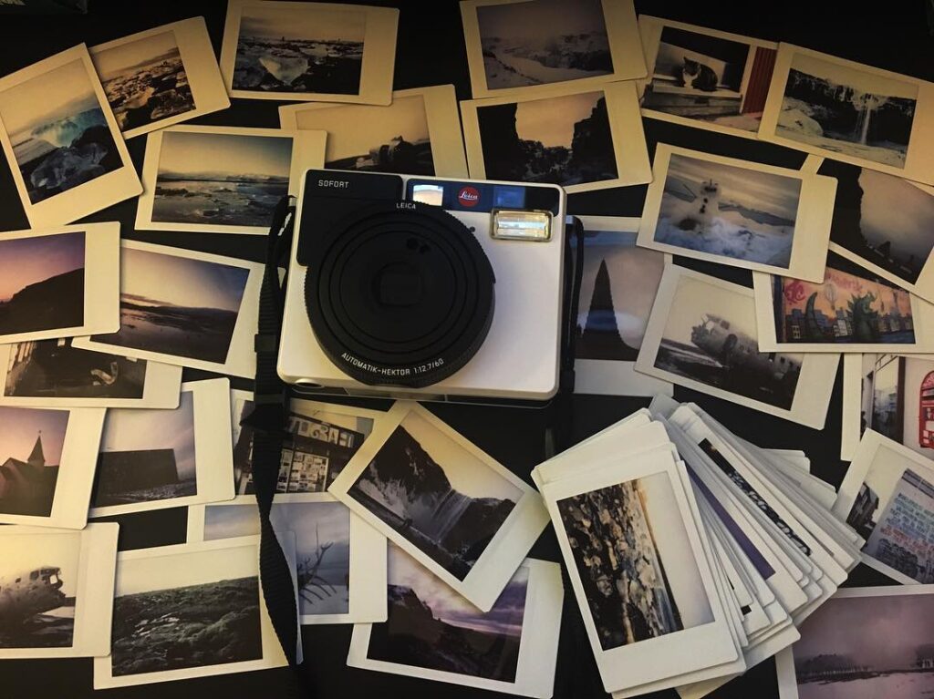 Image of a white camera surrounded by Polaroids