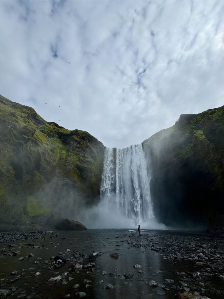 Image of a person near the bottom of a huge waterfall